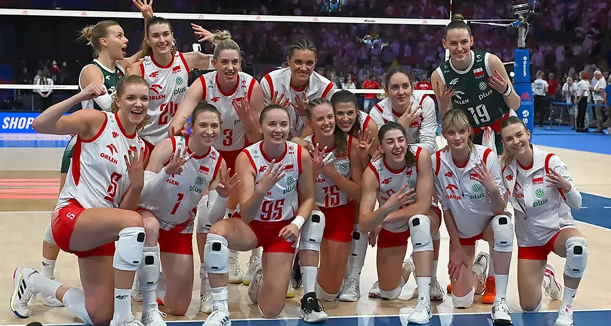 Uśmiechnięte polskie siatkarki w biało-czerwonych strojach pozują do zdjęcia po meczu, dumne ze zwycięstwa.