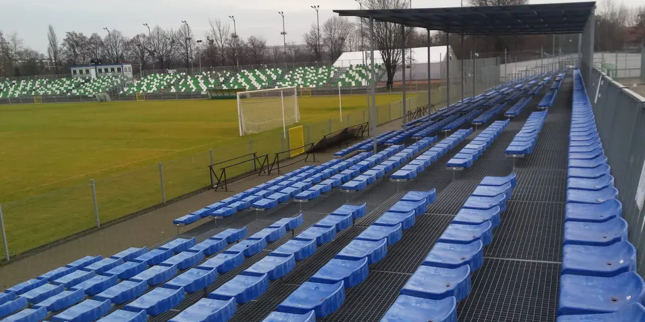 Puste niebieskie krzesełka na stadionie Warty Poznań czekają na kibiców.