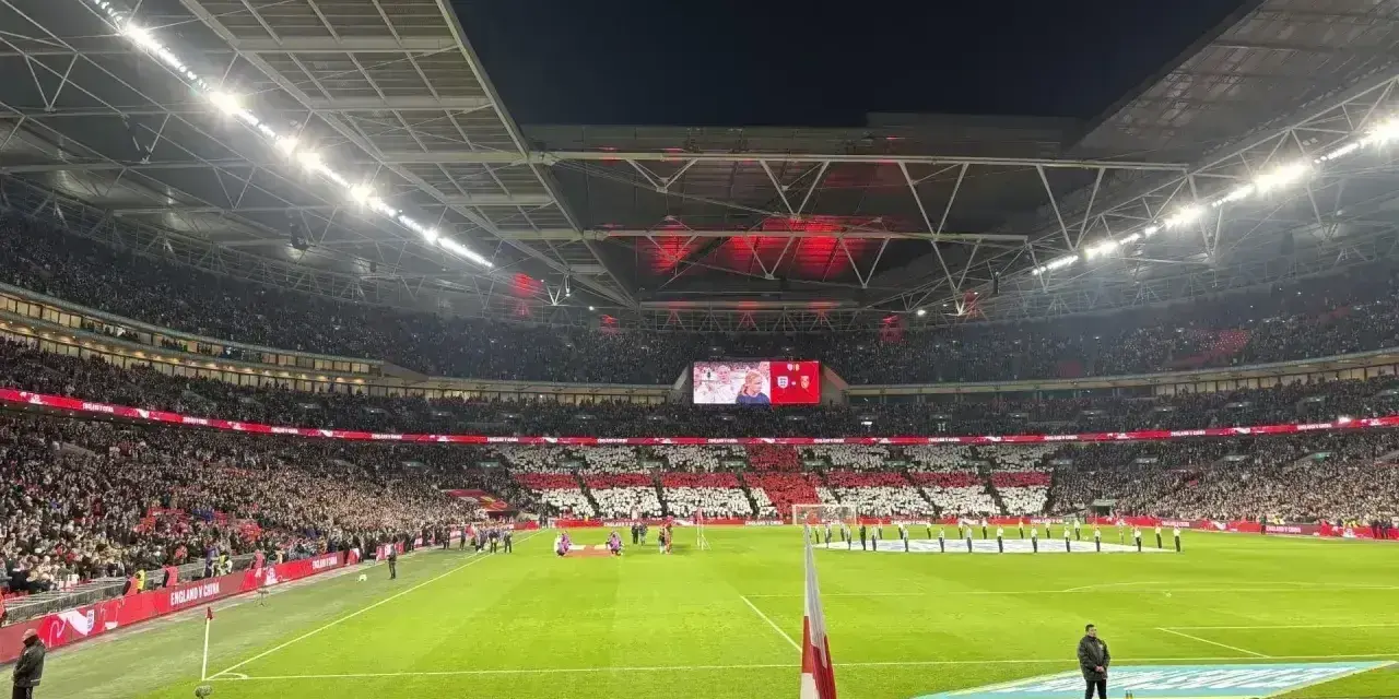 Stadion Wembley podczas meczu, tłumy kibiców tworzą biało-czerwone mozaiki. Emocje jak na najlepszych ligach angielskich.