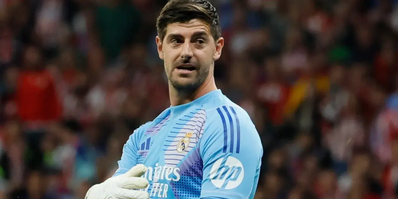 Bramkarz Realu Madryt, Thibaut Courtois, w jasnoniebieskiej koszulce z rękawicami, gotowy do obrony.