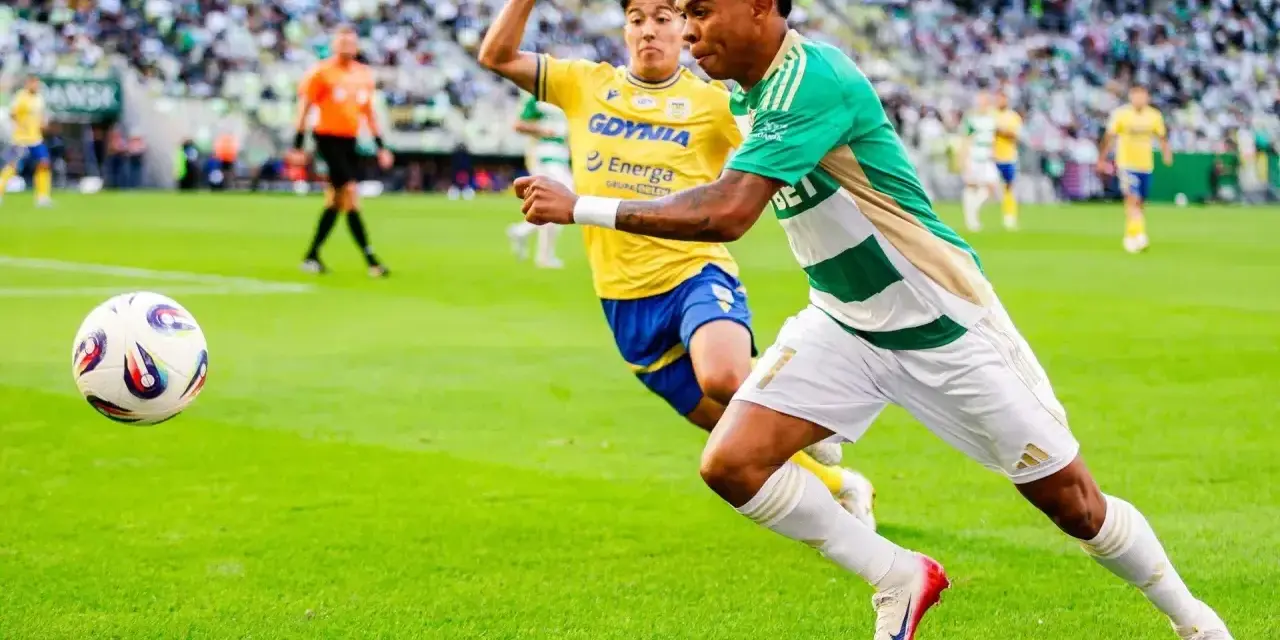 Piłkarz Lechii Gdańsk w zielono-białej koszulce biegnie z piłką, ścigany przez zawodnika Arki Gdynia. Mecz składy: Arka Gdynia – Lechia Gdańsk.
