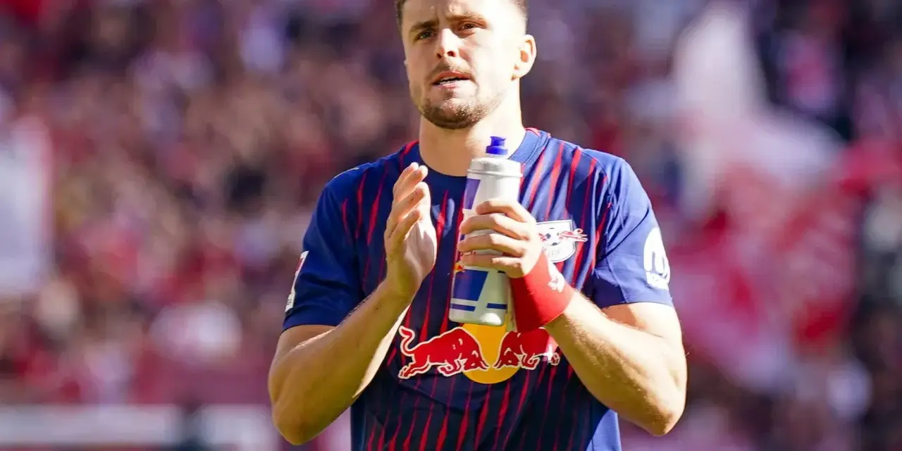 Piłkarz w koszulce RB Leipzig, jeden z zawodników 2. Bundesligi, trzyma butelkę z napojem.