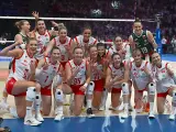 Uśmiechnięte polskie siatkarki w biało-czerwonych strojach pozują do zdjęcia po meczu, dumne ze zwycięstwa.
