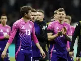 Piłkarze reprezentacji Danii i Niemiec w różowo-fioletowych strojach.