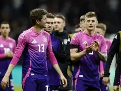 Piłkarze reprezentacji Danii i Niemiec w różowo-fioletowych strojach.