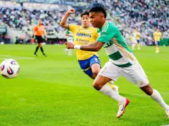 Piłkarz Lechii Gdańsk w zielono-białej koszulce biegnie z piłką, ścigany przez zawodnika Arki Gdynia. Mecz składy: Arka Gdynia – Lechia Gdańsk.