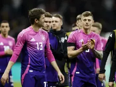 Piłkarze reprezentacji Danii i Niemiec w różowo-fioletowych strojach.
