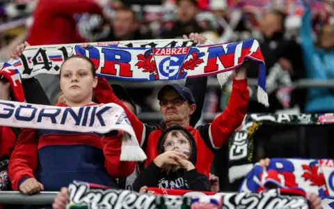 Kibice Górnika Zabrze na meczu z GKS Katowice. Widać szaliki z napisem "Górnik Zabrze" i herbem klubu.