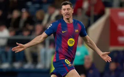 Piłkarz Robert Lewandowski w koszulce FC Barcelony z numerem 9, z rękami rozłożonymi na boki.