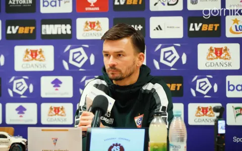 Trener rozmawia o lechia transfery. Na ścianie logo Lechii Gdańsk.
