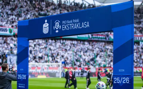 Brama z logo PKO Bank Polski Ekstraklasa na tle stadionu i kibiców. Sezon 25/26.