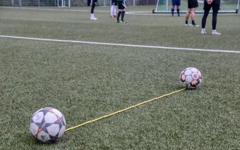 Dwa piłki na boisku połączone żółtą linką. Trening, który pokazuje, jak nie być profesjonalnym piłkarzem.