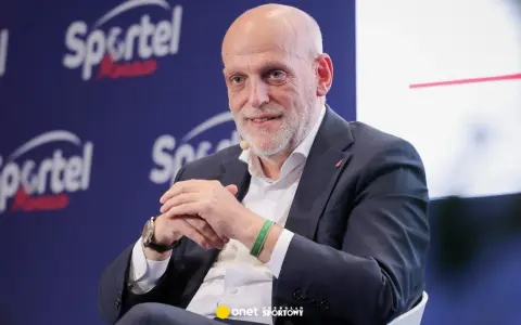 Uśmiechnięty Javier Tebas, prezes La Liga, w garniturze, na tle logo Sportel Forum.