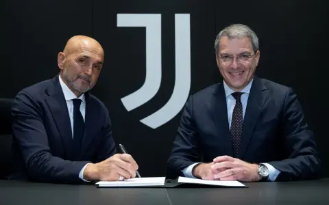 Dwóch mężczyzn w garniturach siedzi przy stole. Jeden z nich, łysy, podpisuje dokument. Za nimi logo Juventusu.