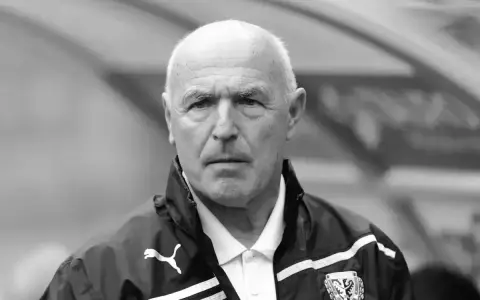 Portret siwowłosego mężczyzny, lenczyk trener piłkarski, w kurtce sportowej z logo Puma.