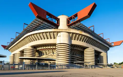 San Siro, ikona Mediolanu, czeka na wyburzenie. Monumentalna konstrukcja stadionu z czerwonymi elementami dachu i betonowymi filarami.