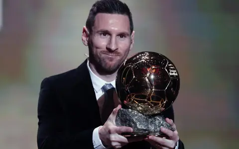 Lionel Messi, który dostał Złotą Piłkę, prezentuje trofeum.