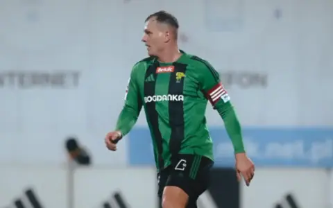 Piłkarz Górnika Łęczna w zielono-czarnej koszulce z opaską kapitana. Mecz z GKS Tychy.