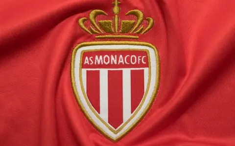 Herb AS Monaco FC na czerwonym tle. Składy: RC Lens – AS Monaco FC.