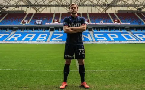 Piłkarz Tymek Puchacz w koszulce Trabzonspor z numerem 72, stoi na murawie stadionu.