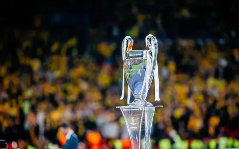 Trofeum Ligi Mistrzów na podium, z tłumem kibiców w tle. Zastanawiasz się, ile za wygranie ligi mistrzów?