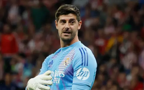 Bramkarz Realu Madryt, Thibaut Courtois, w jasnoniebieskiej koszulce z rękawicami, gotowy do obrony.