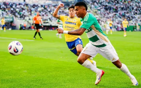 Piłkarz Lechii Gdańsk w zielono-białej koszulce biegnie z piłką, ścigany przez zawodnika Arki Gdynia. Mecz składy: Arka Gdynia – Lechia Gdańsk.