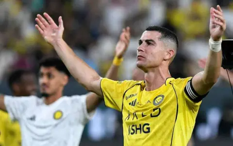 Cristiano Ronaldo w żółtej koszulce z podniesionymi rękami. Ile goli strzelił Ronaldo?