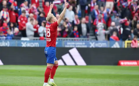Piłkarz w czerwonej koszulce z numerem 18 świętuje bramkę. Kibice na trybunach, dopingują swoją drużynę. To był emocjonujący mecz raków dzisiaj!