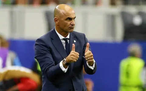 Roberto Martínez, trener Portugalii, pokazuje dwa kciuki w górę, wyrażając aprobatę.