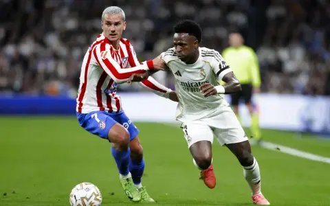 Griezmann z Atletico Madryt walczy o piłkę z Viniciusem z Realu Madryt. Dwa kluby z Madrytu w akcji.