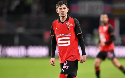 Piłkarz Stade Rennais w czerwonej koszulce z numerem 5, gotowy do gry przeciwko OGC Nice.