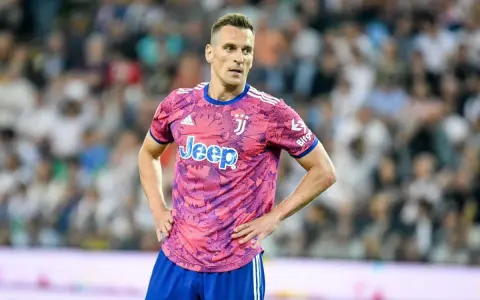 Piłkarz Arkadiusz Milik w różowej koszulce Juventusu z logo Jeep.
