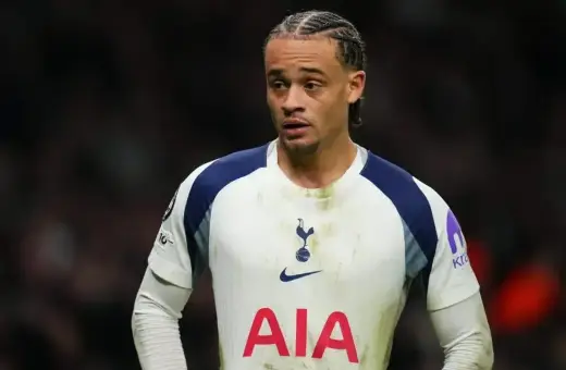Piłkarz Tottenhamu w białej koszulce z granatowymi wstawkami, gotowy do gry przeciwko Luton Town.