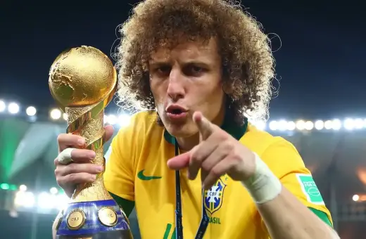 Piłkarz z Brazylii, z bujną fryzurą, triumfalnie trzyma złoty puchar Konfederacji FIFA.