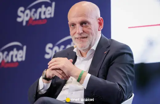 Uśmiechnięty Javier Tebas, prezes La Liga, w garniturze, na tle logo Sportel Forum.