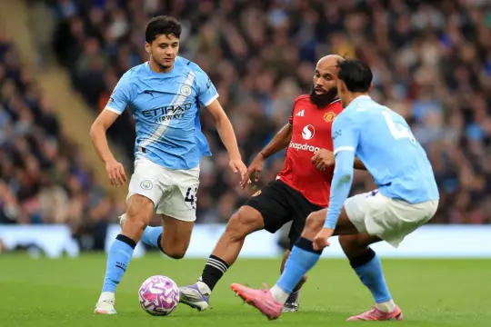 Piłkarz Manchester City w akcji, walczy o piłkę z przeciwnikiem. Skład Manchester City w pełnej krasie.