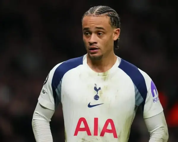 Piłkarz Tottenhamu w białej koszulce z granatowymi wstawkami, gotowy do gry przeciwko Luton Town.