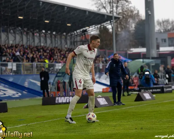 Piłkarz w białej koszulce z numerem 4, przygotowuje się do gry podczas meczu Raków Częstochowa – Widzew Łódź.