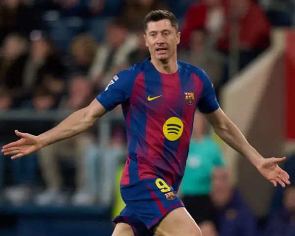 Piłkarz Robert Lewandowski w koszulce FC Barcelony z numerem 9, z rękami rozłożonymi na boki.