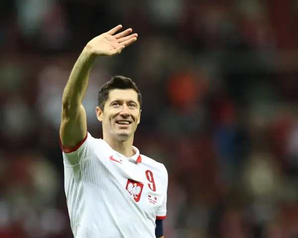 Robert Lewandowski w koszulce reprezentacji Polski z numerem 9, macha do kibiców.