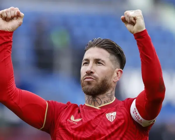 Sergio Ramos w czerwonej koszulce z podniesionymi pięściami, świętuje zwycięstwo. To właśnie tam, gdzie gra Sergio Ramos, czuć emocje!