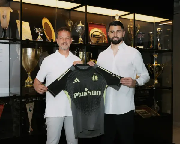 Nowy bramkarz Legii, w otoczeniu trofeów, prezentuje nowy strój.