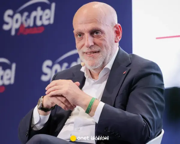 Uśmiechnięty Javier Tebas, prezes La Liga, w garniturze, na tle logo Sportel Forum.