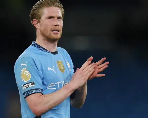 Kevin De Bruyne w błękitnej koszulce Manchesteru City klaszcze, wyrażając uznanie dla kibiców.
