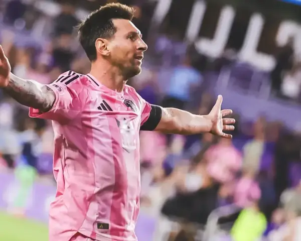 Piłkarz w różowej koszulce świętuje bramkę. To Lionel Messi, który grał w klubach takich jak FC Barcelona, PSG i Inter Miami.