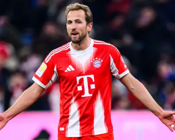 Piłkarz Harry Kane w czerwonej koszulce Bayernu Monachium, zastanawia się, ile zarabia.