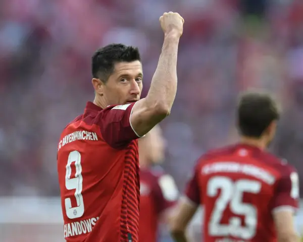 Piłkarz Robert Lewandowski w czerwonej koszulce z numerem 9 świętuje bramkę.