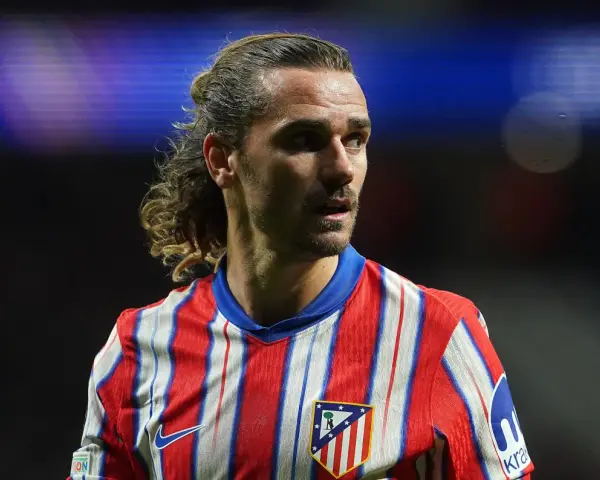 Grizman w koszulce Atletico Madryt, z charakterystyczną fryzurą, skupiony na boisku.