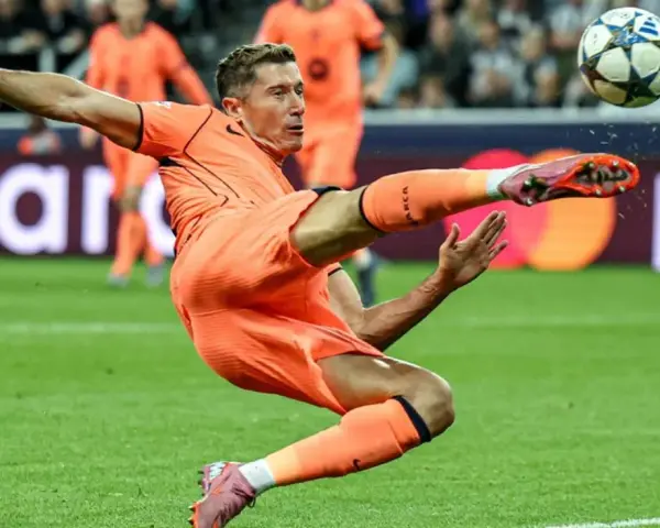 Piłkarz w pomarańczowym stroju wykonuje akrobatyczne kopnięcie do piłki. To Robert Lewandowski, który gra w Lidze Mistrzów.